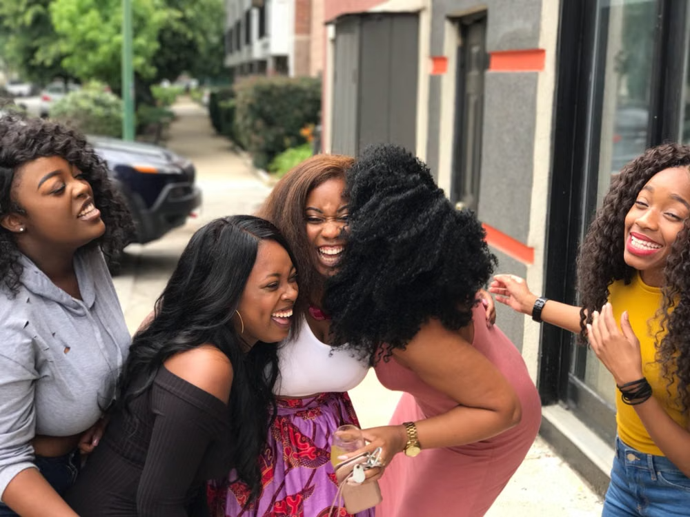 Black women laughing and gathering together