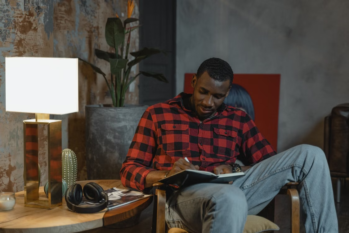 Black man journaling in a reflective setting